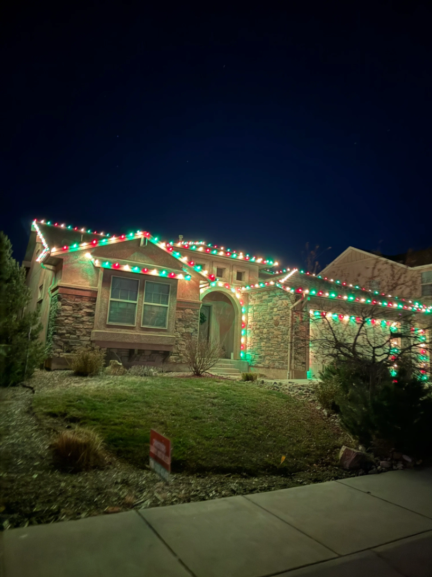 Multicolor LED roofline and landscape accents on a two-story home — company portfolio